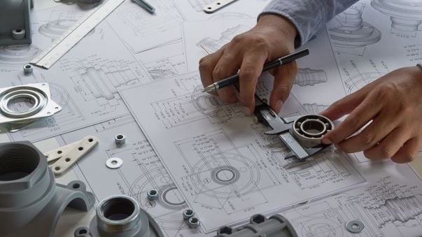 Engineer looking at drawings and components