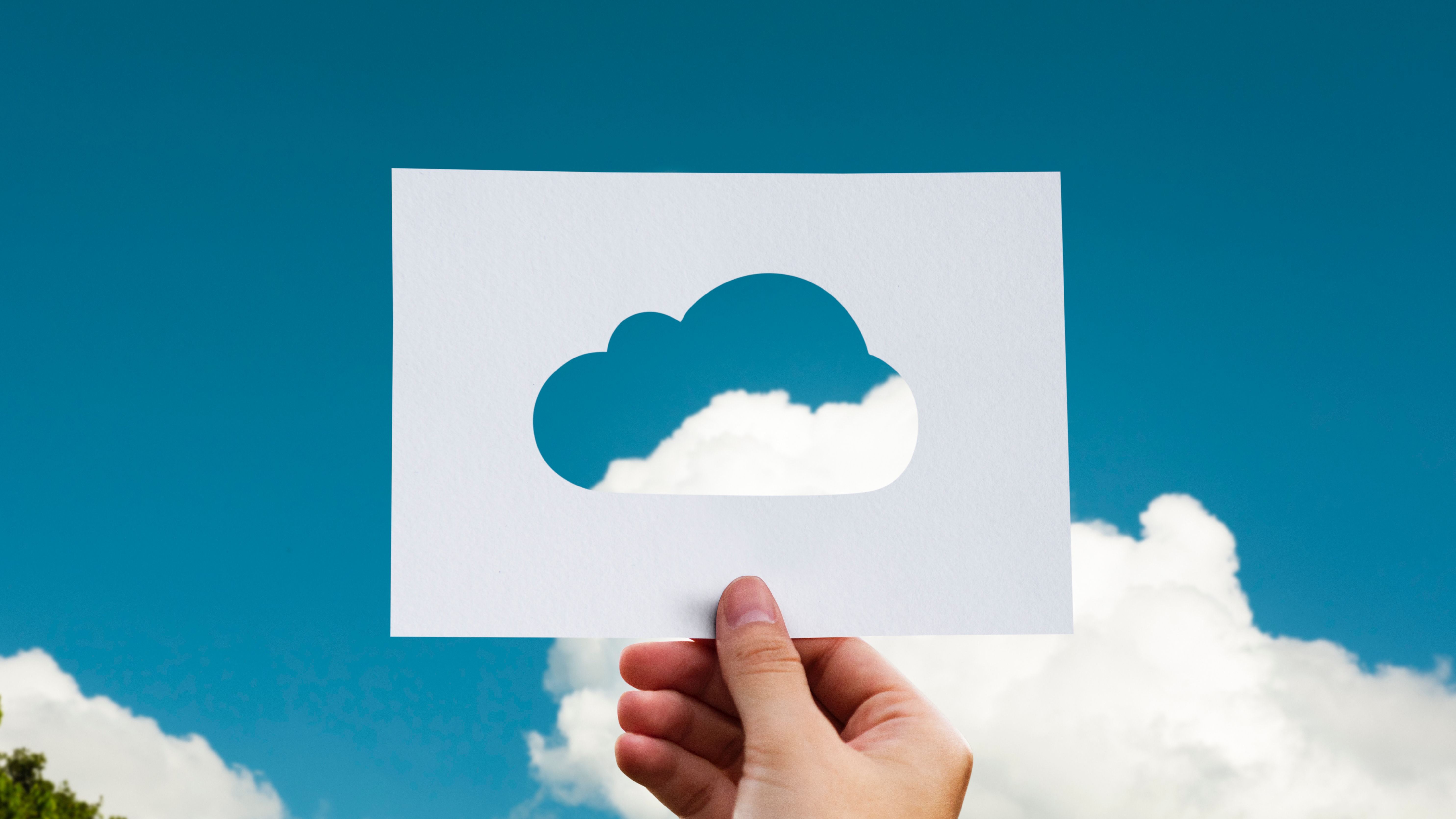 An R&D tax credit advisor holding a cut out image of a cloud against a blue sky