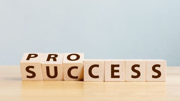 Wooden cube block flip over word process to success on wood table
