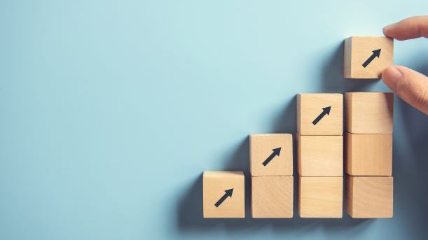 Business concept growth success process, Close up Woman hand arranging wood block stacking as step stair on paper blue background, copy space.