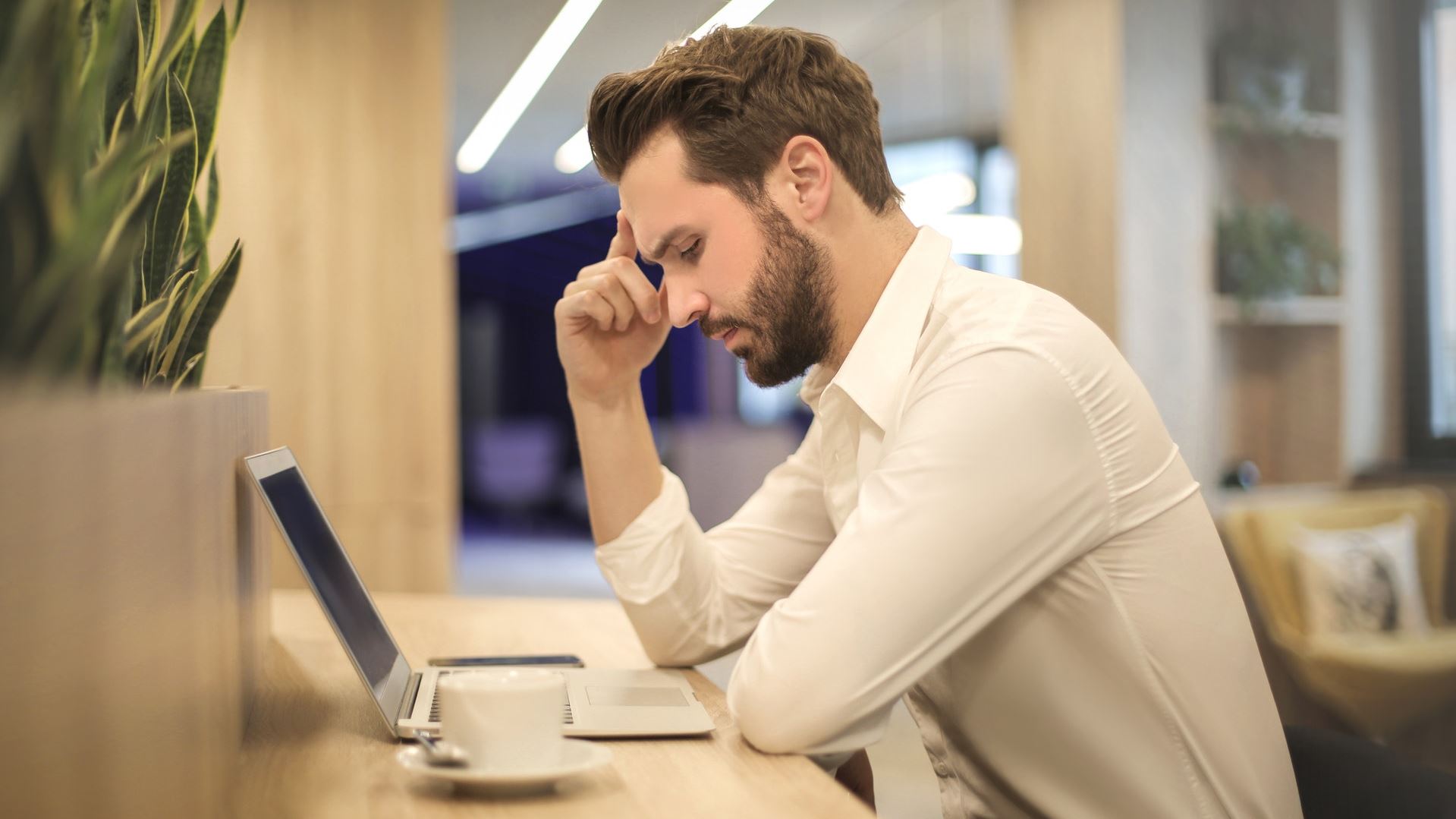 Man thinking infront of his laptop