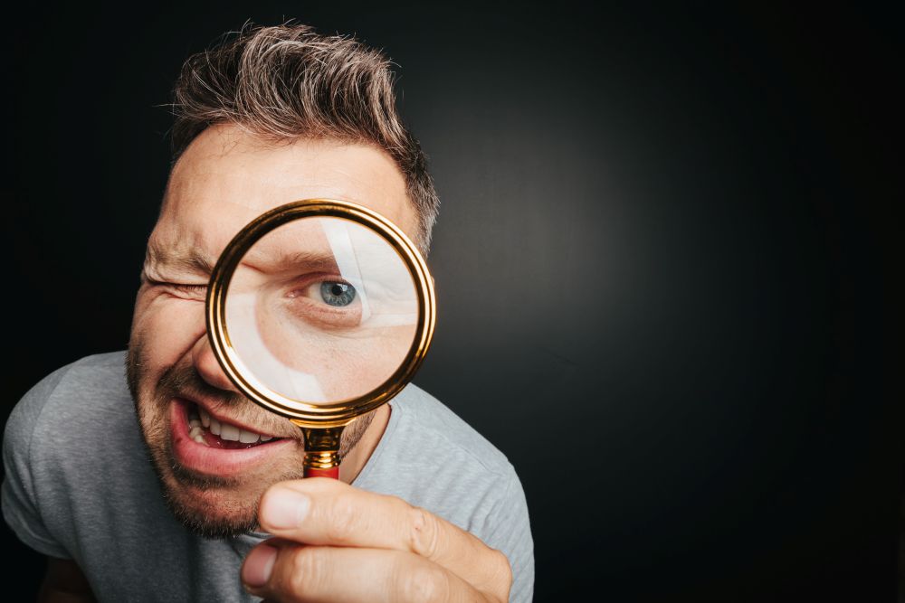 Man Looking Through Magnifying Glass