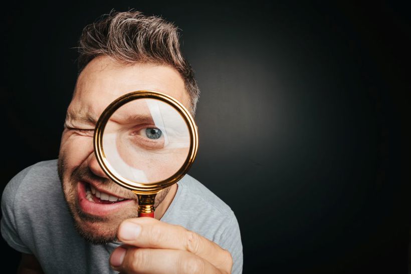 Man Looking Through Magnifying Glass