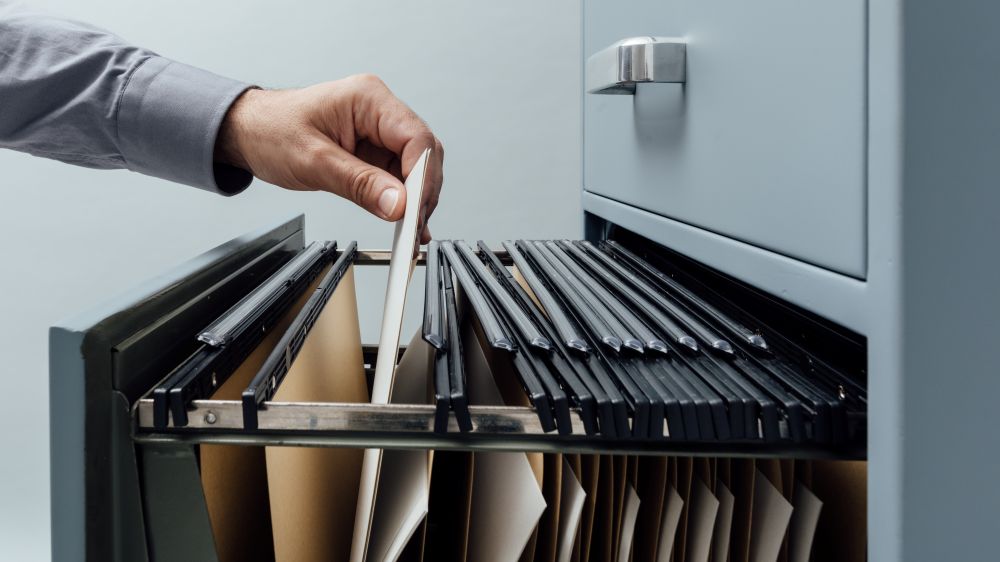 Office Clerk Searching For Files Into A Filing Cabinet Drawer Close Up