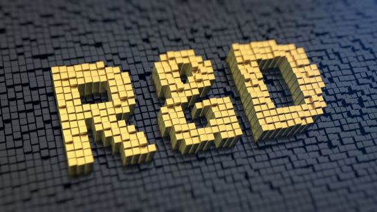 3D yellow blocks forming the letters R&D on a dark tiled surface, representing research and development.